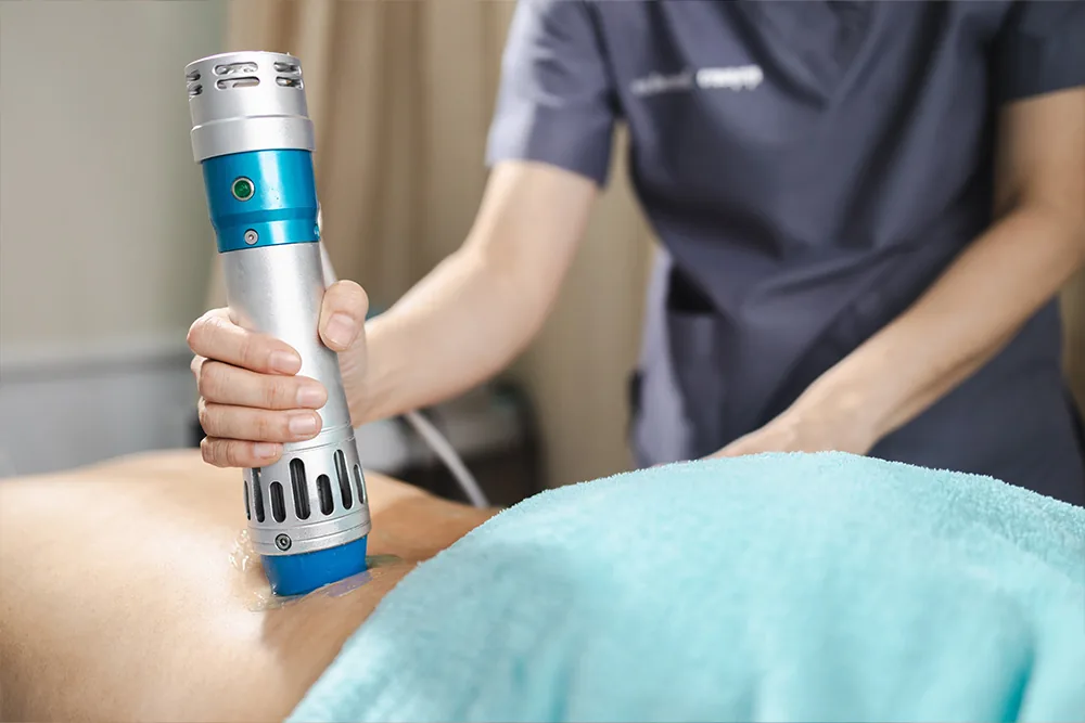 Clinician applying shockwave therapy device to a patient's back